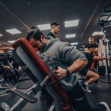 Man with man bun hairstyle, on a bench using a GymPin D Handle Bar to carry out some cable row exercises. 