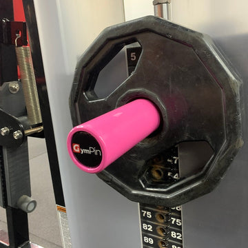 Black weight plate with pink handle labeled 'GymPin' on a gym machine.