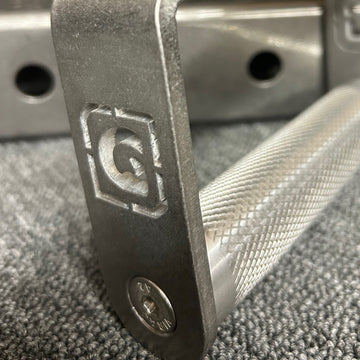 A close-up of a stainless steel fixed roller D handle used for gym equipment, showing the knurling and the brand logo.