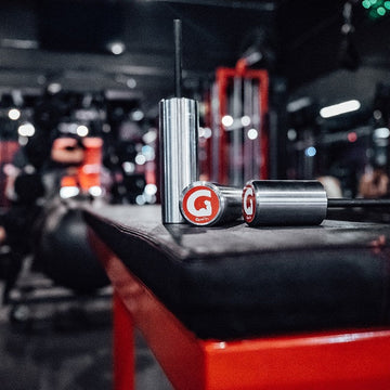 The Original GymPin displayed on a gym bench, designed for progressive overload with cable machines.