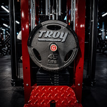 Troy weight plate on a red weightlifting machine in a gym setting witha  GymPin