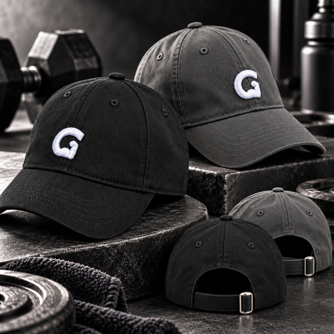 Black and grey GymPin baseball caps styled in a premium gym setting