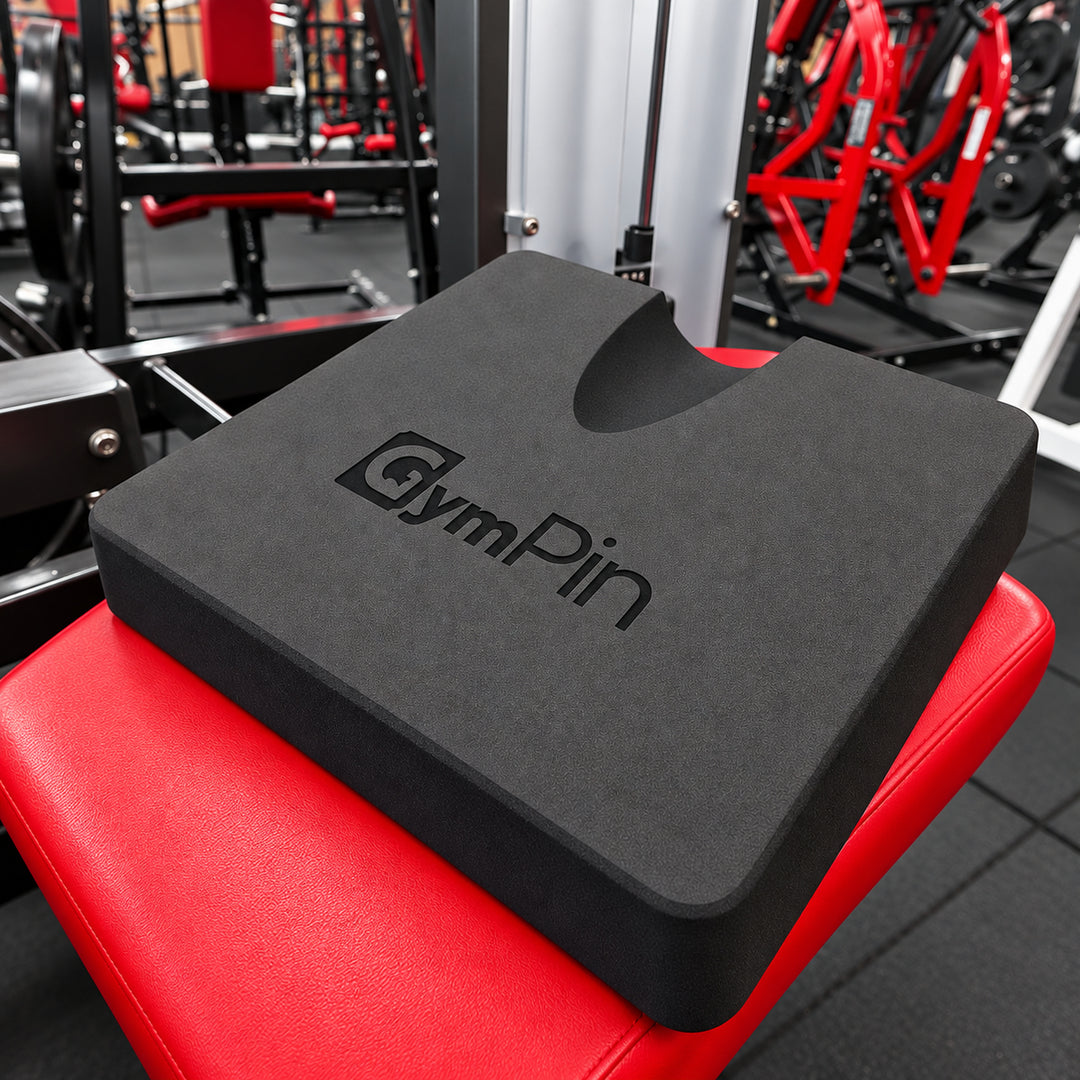 GymPin hamstring pad resting on a red leg curl bench