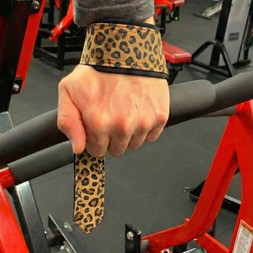 Hand wearing a leopard print wrist wrap on a gym machine.